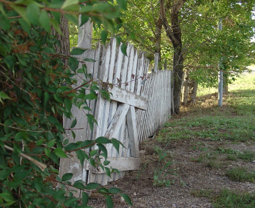 White fence in dire need of repair