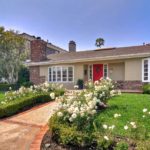 Newport Beach home with white roses and green grass