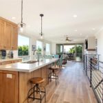 Living room of modern loft with wood floors, ample light and colorful kitchen backsplash