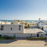 Newport Beach duplex with ocean and sand in the background and bike rider in front