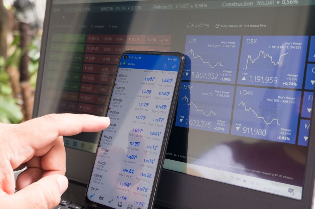 computer and phone display of stockmarket graphs