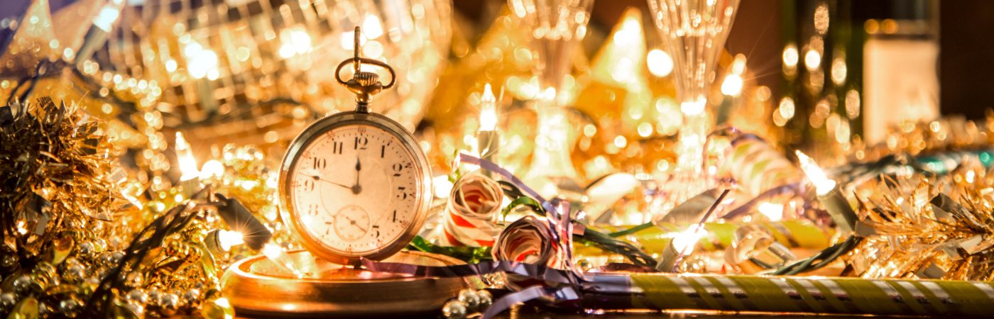 new years party - clock in foreground and pretty lights surrounding.