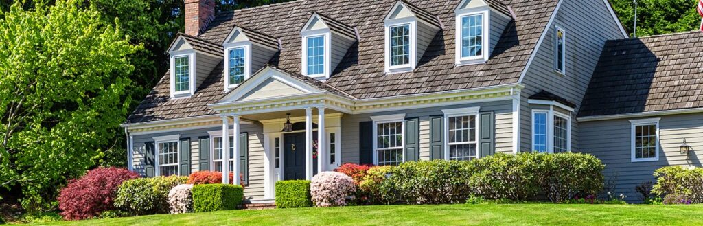 nice home with green grass and bushes and pristine landscape