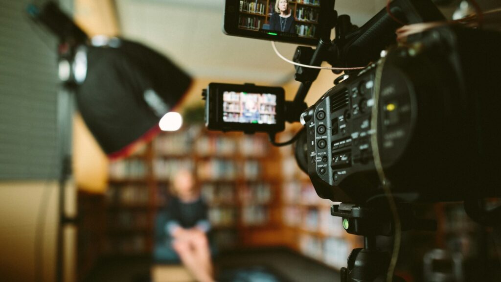 person sitting in front bookshelf A snap shot of our Sony FS7 cinema camera system from our film set,